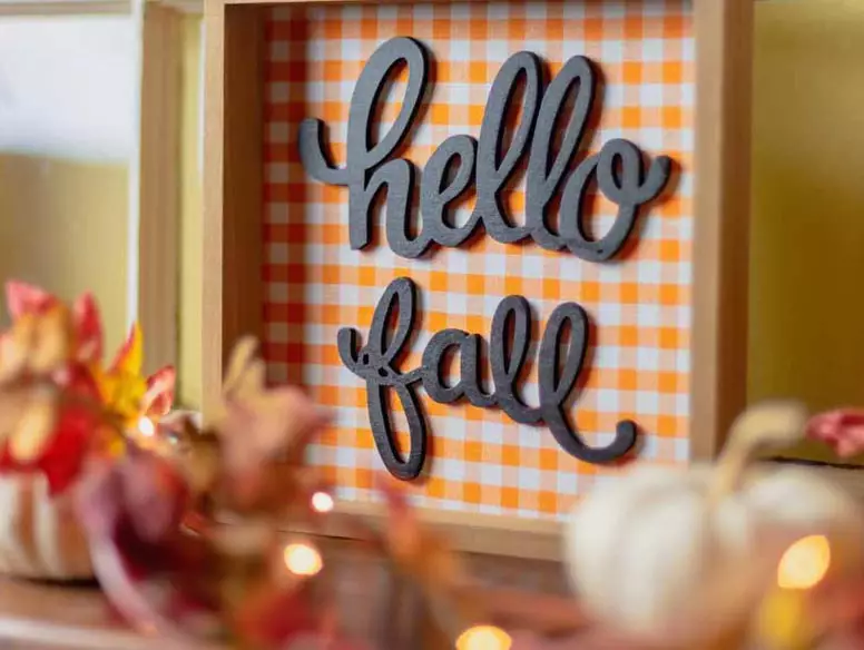 Autumn decorations with sign that says Hello Fall