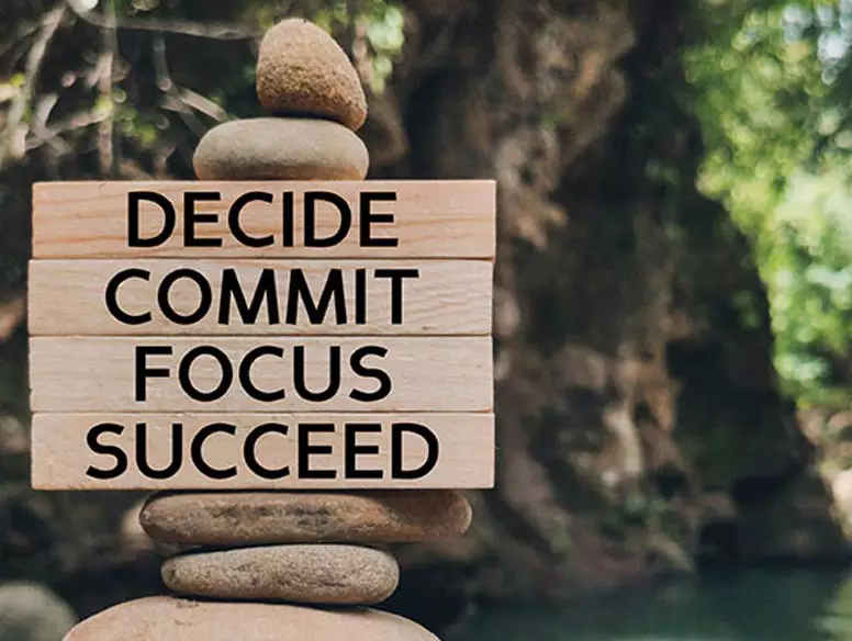 Photo of stacked rocks with the words decide, commit, focus and succeed