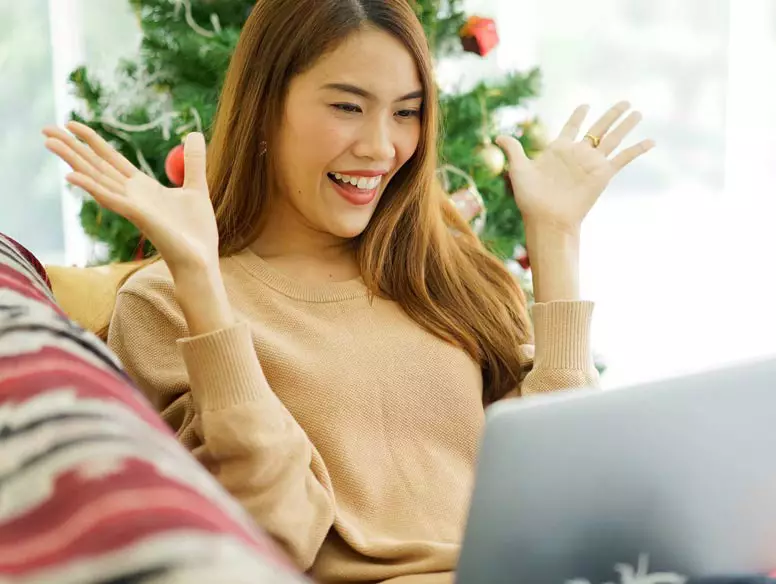 Photo of woman laughing at Zoom game on laptop