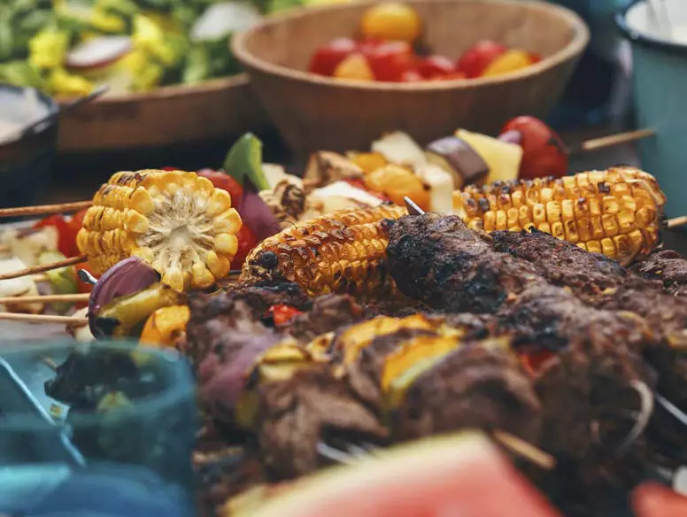 Photo of table with various grilled vegetables and meats