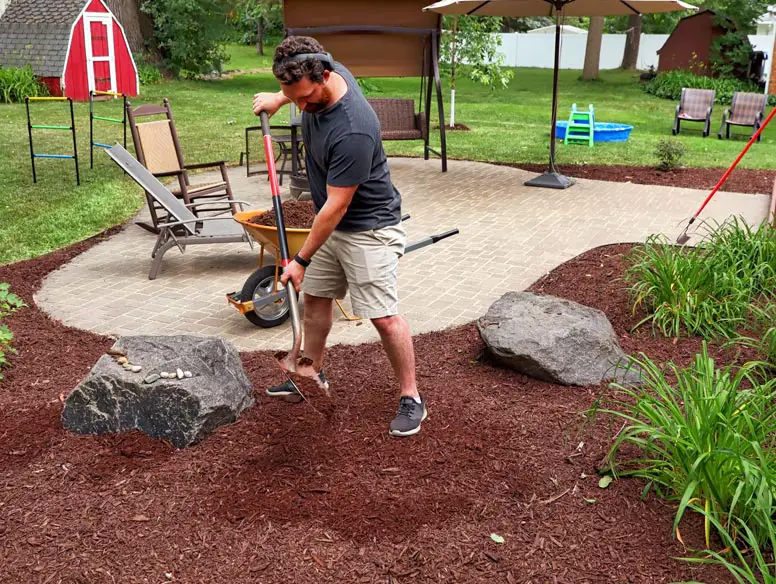Man mulching his backyard garden
